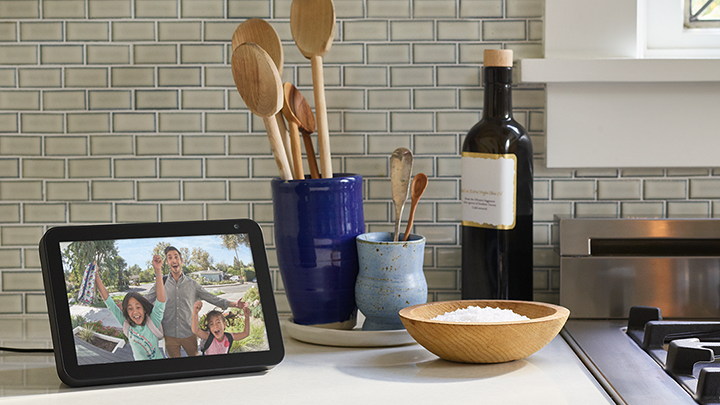 Amazon Echo Show on kitchen counter showing Ring doorbell live view with guests waiting at the door